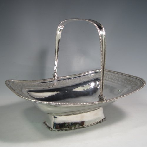 Antique Georgian sterling silver basket, having a rectangular body, with applied gadroon borders, a band of hand-engraved floral work, a central cartouche with matching engraving, a hinged and swing handle, all sitting on a pedestal foot. Made by David and Robert Hennell (Poss.) of London in 1804. The dimensions of this fine hand-made silver basket are height 25 cms (10 inches), length 31 cms (12.25 inches), width 24 cms (9.5 inches), and it weighs approx. 1,021g (33 troy ounces).