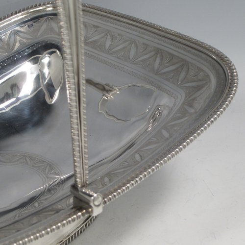 Antique Georgian sterling silver basket, having a rectangular body, with applied gadroon borders, a band of hand-engraved floral work, a central cartouche with matching engraving, a hinged and swing handle, all sitting on a pedestal foot. Made by David and Robert Hennell (Poss.) of London in 1804. The dimensions of this fine hand-made silver basket are height 25 cms (10 inches), length 31 cms (12.25 inches), width 24 cms (9.5 inches), and it weighs approx. 1,021g (33 troy ounces).
