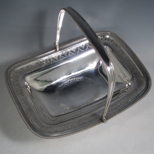 Antique Georgian sterling silver basket, having a rectangular body, with applied gadroon borders, a band of hand-engraved floral work, a central cartouche with matching engraving, a hinged and swing handle, all sitting on a pedestal foot. Made by David and Robert Hennell (Poss.) of London in 1804. The dimensions of this fine hand-made silver basket are height 25 cms (10 inches), length 31 cms (12.25 inches), width 24 cms (9.5 inches), and it weighs approx. 1,021g (33 troy ounces).