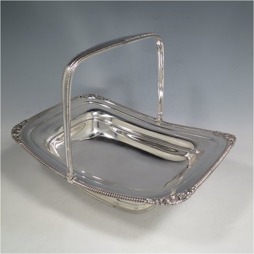 An Antique Edwardian Sterling Silver basket, having a rectangular body, with an applied gadroon and shell border, a hinged and swing handle with gadroon edges, all sitting on a plain pedestal foot. Made by the Barnard Brothers of London in 1903. The dimensions of this fine hand-made silver basket are height 21 cms (8.25 inches), length 27.5 cms (10.75 inches), width 20.5 cms (8 inches), and it weighs approx. 701g (22.6 troy ounces).   