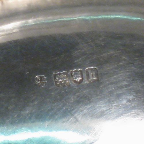 An elegant Antique Edwardian Sterling Silver table basket, having a plain oval body with shaped border and applied reeded edge, a hinged reeded handle, and sitting on a collet foot with reeded border. This handsome silver basket was made by Charles Stuart Harris of London in 1903. The dimensions of this fine hand-made antique silver basket are height inc. handle 20 cms (8 inches), length 23 cms (9 inches), 19 cms (7.5 inches), and it weighs approx. 339g (11 troy ounces).