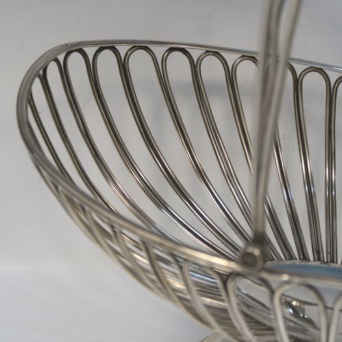A handsome Antique Georgian Old Sheffield Silver-Plated basket, having an oval body all formed from wire-work decoration, a hinged wire-work swing handle, and all sitting on a plain oval stepped pedestal foot. This elegant antique basket was made in ca. 1790. The dimensions of this fine hand-made antique 18th Century Old Sheffield Silver-Plated basket are height (inc. handle) 30.5 cms (12 inches), length 32 cms (12.5 inches), and width 21 cms (8.25 inches).
