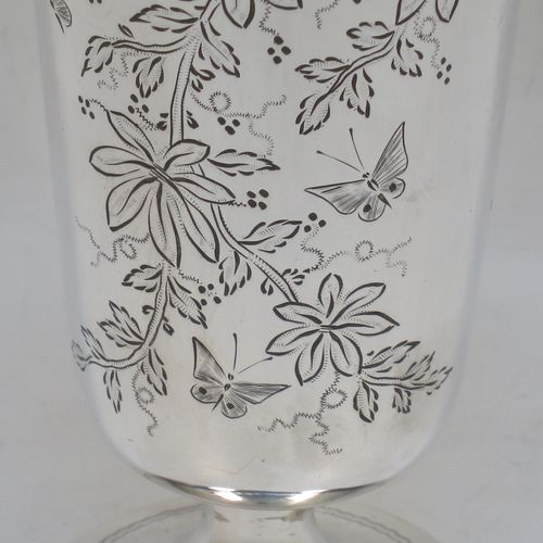 A very pretty Antique Victorian Sterling Silver beaker, having a round straight-sided body with tapering sides, with hand-engraved floral decoration and butterflies, and vacant cartouches either side, and all sitting on a round pedestal foot. Made by Charles Boyton of London in 1885. The dimensions of this fine hand-made antique silver beaker are height 14 cms (5.5 inches), diameter at top 6.5 cms (2.5 inches), and it weighs approx. 171g (5.5 troy ounces).