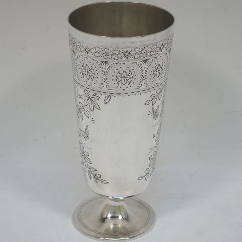 A very pretty Antique Victorian Sterling Silver beaker, having a round straight-sided body with tapering sides, with hand-engraved floral decoration and butterflies, and vacant cartouches either side, and all sitting on a round pedestal foot. Made by Charles Boyton of London in 1885. The dimensions of this fine hand-made antique silver beaker are height 14 cms (5.5 inches), diameter at top 6.5 cms (2.5 inches), and it weighs approx. 171g (5.5 troy ounces).