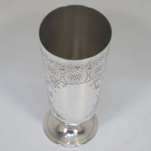 A very pretty Antique Victorian Sterling Silver beaker, having a round straight-sided body with tapering sides, with hand-engraved floral decoration and butterflies, and vacant cartouches either side, and all sitting on a round pedestal foot. Made by Charles Boyton of London in 1885. The dimensions of this fine hand-made antique silver beaker are height 14 cms (5.5 inches), diameter at top 6.5 cms (2.5 inches), and it weighs approx. 171g (5.5 troy ounces).