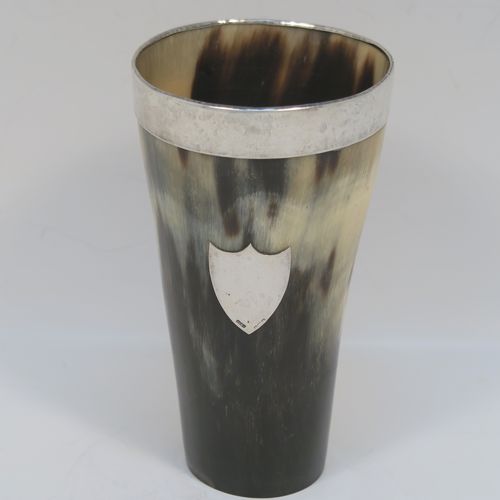 A rare and handsome Antique Sterling Silver and horn beaker cup, having a very plain round horn-mounted body with tapering sides, an applied top silver band around the lip, an applied central shield style vacant cartouche, and all sitting on a flat base. This elegant silver and horn beaker was made by John Grinsell and Sons of Birmingham in 1913. The dimensions of this fine hand-made antique horn and silver beaker cup are height 13cms (5 inches), and diameter at top 7 cms (2.75 inches).  