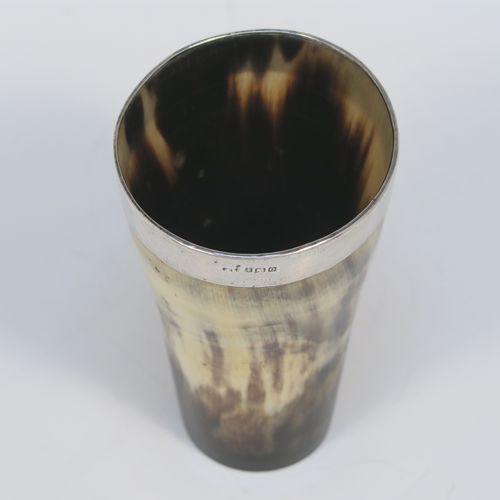 A rare and handsome Antique Sterling Silver and horn beaker cup, having a very plain round horn-mounted body with tapering sides, an applied top silver band around the lip, an applied central shield style vacant cartouche, and all sitting on a flat base. This elegant silver and horn beaker was made by John Grinsell and Sons of Birmingham in 1913. The dimensions of this fine hand-made antique horn and silver beaker cup are height 13cms (5 inches), and diameter at top 7 cms (2.75 inches).