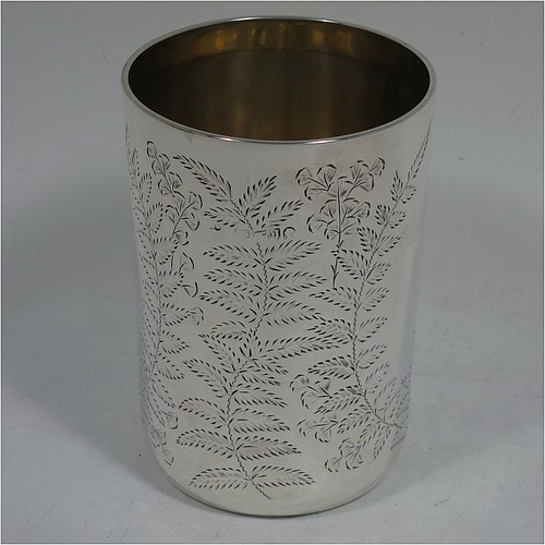 An Antique Victorian Sterling Silver beaker, having a round straight-sided body with tucked under flat base, with hand-engraved fern-work, two vacant oval cartouches on either side, with a gold-gilt interior, and in its original dark blue satin and velvet-lined presentation box. Made by Wakely and Wheeler of London in 1887. The dimensions of this fine hand-made antique silver beaker are height 10 cms (4 inches), diameter at top 7 cms (2.75 inches), and it weighs approx. 129g (4.2 troy ounces). Please note that the box is embossed with initials on the exterior.