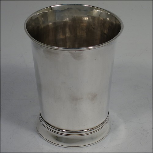 A very handsome Antique Georgian Sterling Silver beaker, having a very plain round body with tapering sides, reeded top and bottom borders, and sitting on a collet foot. Made by Thomas Wallis I of London in 1770. The dimensions of this fine hand-made antique silver beaker are height 9 cms (3.5 inches), diameter at top 7 cms (2.75 inches), and it weighs approx. 123g (4 troy ounces).