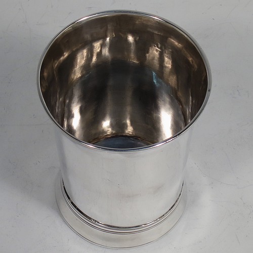 A very handsome Antique Georgian Sterling Silver beaker, having a very plain round body with tapering sides, reeded top and bottom borders, and sitting on a collet foot. Made by Thomas Wallis I of London in 1770. The dimensions of this fine hand-made antique silver beaker are height 9 cms (3.5 inches), diameter at top 7 cms (2.75 inches), and it weighs approx. 123g (4 troy ounces).