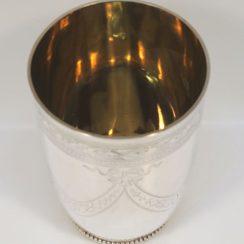 A beautiful Antique Victorian Sterling Silver beaker, having a round body with tapering sides, with hand-engraved floral and swag decoration, a gold-gilt interior, and all sitting on a collet foot with an applied bead-edged border. This very pretty silver beaker was made in Sheffield in 1874. The dimensions of this fine hand-made antique silver beaker are height 11 cms (4.25 inches), diameter at top 8 cms (3.25 inches), and it weighs approx. 170g (5.5 troy ounces).