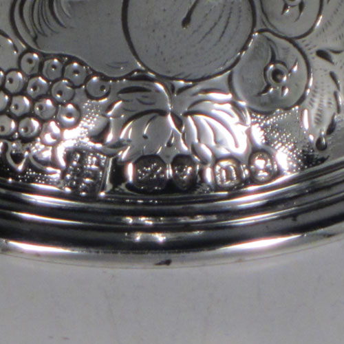 Antique Georgian sterling silver table bell having a round baluster body with hand-chased fruit and floral decoration, a cast octagonal handle, and an original silver clapper. Made by the Lias Brothers of London in 1828. The dimensions of this fine hand-made antique silver table bell are height 14 cms (5.5 inches), diameter at base 8 cms (3 inches), and it weighs approx. 225g (7.3 troy ounces).