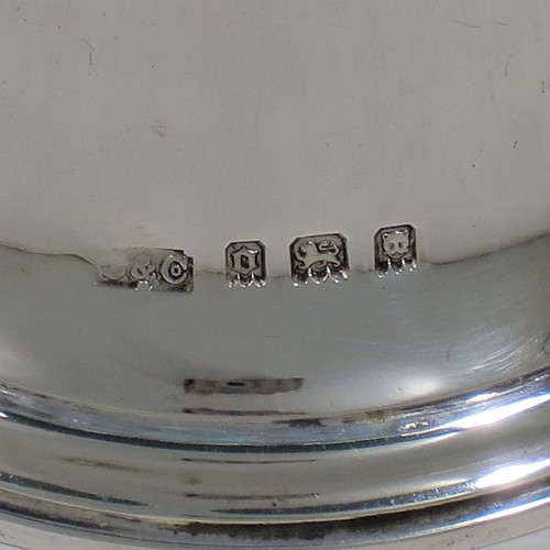 A Sterling Silver Georgian style table bell having a plain round body with applied reeded borders, a cast baluster handle, and an original silver clapper. Made by Carrington and Co., of London in 1929. The dimensions of this fine hand-made silver table bell are height 10.5 cms (4.25 inches), diameter at base 6 cms (2.3 inches), and it weighs approx. 165g (5.3 troy ounces).