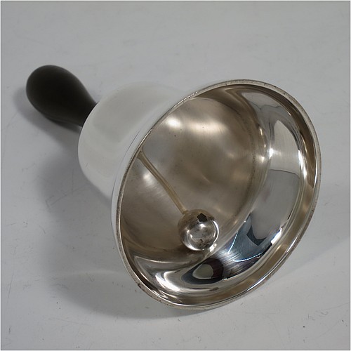 A Sterling Silver pair of Georgian style table bells, having plain round bellied bodies, with hand-turned wooden handles, and original silver clappers, all in their original cream satin and black velvet-lined presentation box. Made by Gladwin and Co., Ltd., of Sheffield in 1935. The dimensions of this fine hand-made pair of silver table bells are height 11.5 cms (4.5 inches), diameter at base 6.5 cms (2.5 inches), and they weigh a total of approx. 280g (9 troy ounces).