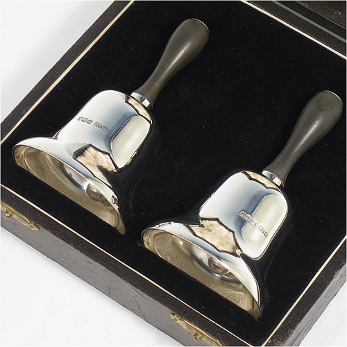 A Sterling Silver pair of Georgian style table bells, having plain round bellied bodies, with hand-turned wooden handles, and original silver clappers, all in their original cream satin and black velvet-lined presentation box. Made by Gladwin and Co., Ltd., of Sheffield in 1935. The dimensions of this fine hand-made pair of silver table bells are height 11.5 cms (4.5 inches), diameter at base 6.5 cms (2.5 inches), and they weigh a total of approx. 280g (9 troy ounces).