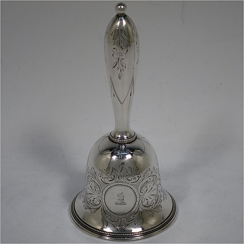 A very pretty Antique Victorian Sterling Silver table bell having a round baluster body with hand-engraved floral and scroll decoration, a tear-drop shaped handle with ball finial, with applied bead-edged borders, and an original silver clapper. Made by Hayne and Cater of London in 1863. The dimensions of this fine hand-made antique silver table bell are height 14 cms (5.5 inches), diameter at base 7 cms (2.75 inches), and it weighs approx. 132g (4.25 troy ounces). Please note that this item is crested. 
