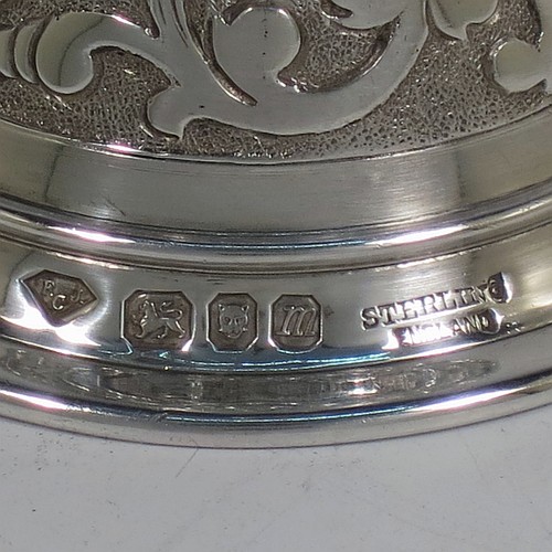 A very handsome, large and heavy sterling silver table bell having a round baluster body with hand-chased acanthus-leaf, scroll and floral decoration, a cast floral and scroll handle, and an original silver clapper. Made in London in 1967. The dimensions of this fine hand-made silver table bell are height 18 cms (7 inches), diameter at base 7 cms (2.75 inches), and it weighs approx. 361g (11.6 troy ounces).