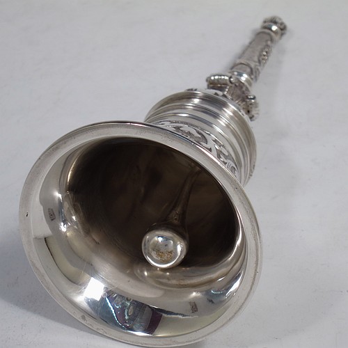 A very handsome, large and heavy sterling silver table bell having a round baluster body with hand-chased acanthus-leaf, scroll and floral decoration, a cast floral and scroll handle, and an original silver clapper. Made in London in 1967. The dimensions of this fine hand-made silver table bell are height 18 cms (7 inches), diameter at base 7 cms (2.75 inches), and it weighs approx. 361g (11.6 troy ounces).