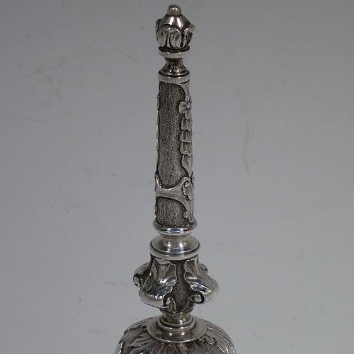 A very handsome, large and heavy sterling silver table bell having a round baluster body with hand-chased acanthus-leaf, scroll and floral decoration, a cast floral and scroll handle, and an original silver clapper. Made in London in 1967. The dimensions of this fine hand-made silver table bell are height 18 cms (7 inches), diameter at base 7 cms (2.75 inches), and it weighs approx. 361g (11.6 troy ounces).