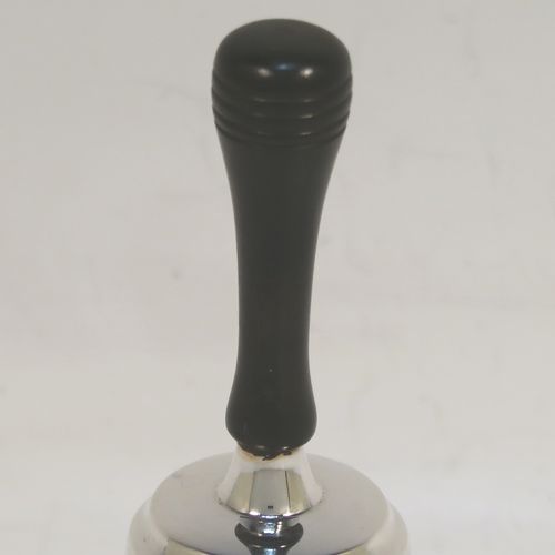 A handsome Sterling Silver table bell having a plain round body, a black stained wooden handle, and an original silver clapper on a chain. This elegant silver bell was made by Cooper Brothers and Sons of Sheffield in 1979. The dimensions of this fine hand-made silver table bell are height 11 cms (4.3 inches), diameter at base 6 cms (2.3 inches), and it weighs approx. 60g (1.9 troy ounces).