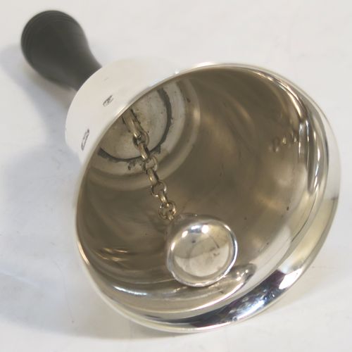 A handsome Sterling Silver table bell having a plain round body, a black stained wooden handle, and an original silver clapper on a chain. This elegant silver bell was made by Cooper Brothers and Sons of Sheffield in 1979. The dimensions of this fine hand-made silver table bell are height 11 cms (4.3 inches), diameter at base 6 cms (2.3 inches), and it weighs approx. 60g (1.9 troy ounces).