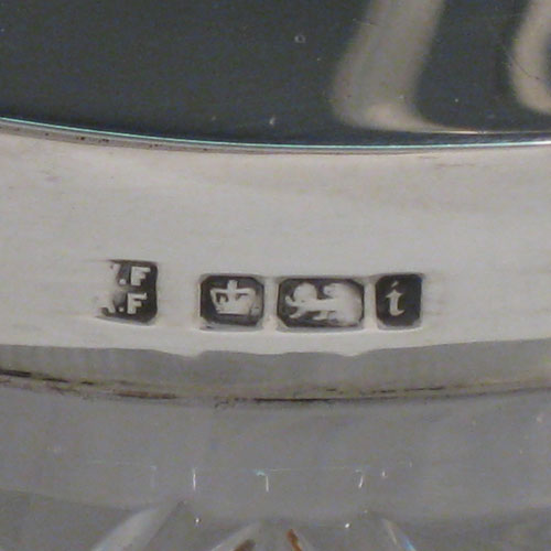 A very pretty Antique Victorian Sterling Silver and hand-cut crystal biscuit jar, having an unusual oval crystal body with hand-cut floral and geometric work, a lift-off lid with half-fluting and wooden finial, and a wire-work swing handle. Made by Fordham and Faulkner of Sheffield in 1901. The dimensions of this fine hand-made antique silver and crystal biscuit jar are height 18 cms (7 inches), length 20 cms (8 inches), and width 15 cms (6 inches).