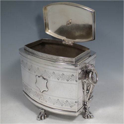 An Antique Victorian Silver Plated biscuit box, having a Neoclassical style rectangular shaped body with straight sides, applied bead-edged borders, with two bands of hand-engraving above and below a vacant cartouche, a hinged lid with ivory finial, two cast lion-mask ring handles, and all sitting on four cast lions-paw feet. Made in ca. 1880. The dimensions of this fine hand-made silver-plated biscuit boxr are height 18 cms (7 inches), length 21 cms (8.25 inches), and width 15 cms (6 inches).