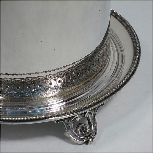 A very pretty Antique Victorian Silver Plated biscuit box, having a round body with straight sides and applied bead-edged borders, with very pretty hand-engraved bands of geometrical and floral work, a hinged flat lid with bone finial, and all sitting on an attached plate with four cast scroll and shell feet. Made by Elkington and Co., of Sheffield in ca. 1880. The dimensions of this fine hand-made antique silver-plated biscuit box are height 16 cms (6.3 inches), and diameter at base 18 cms (7 inches).
