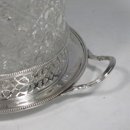 Antique Victorian sterling silver and hand-cut crystal biscuit jar, having a hobnail cut body, a lift-off lid with hand-engraved floral work and a cast flower finial, all sitting inside a two-handled plate with a hand-pierced gallery and bead-edge border. Made by Henry Wilkinson and Co., of Sheffield in 1867. The dimensions of this fine hand-made silver and crystal biscuit box are height 18 cms (6.3 inches), and diameter of base 17 cms (6.75 inches).