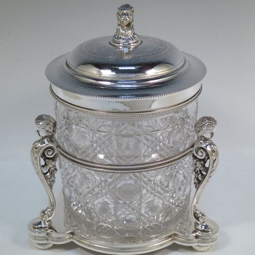 A very pretty Antique Victorian silver-plated and hand-cut crystal biscuit jar, having a hobnail and star cut body, a hinged lid with hand-engraved floral work and a cast leopards head finial, all sitting inside a galleried base with three cast caryatid figures attached to a central band and sitting on three cushion feet, all with bead-edge borders. Made by Henry Atkins of Sheffield in ca. 1880. The dimensions of this fine hand-made silver plated and crystal biscuit box are height 21.5 cms (8.5 inches), and diameter of base 15 cms (6 inches).  