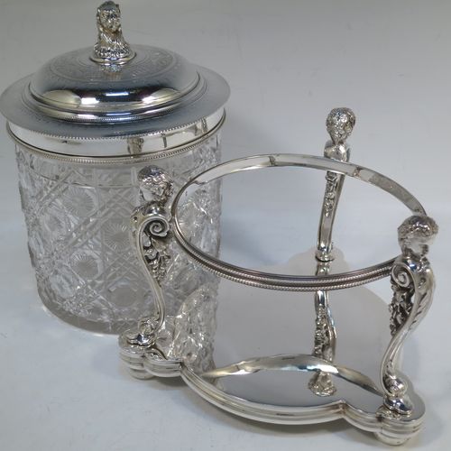 A very pretty Antique Victorian silver-plated and hand-cut crystal biscuit jar, having a hobnail and star cut body, a hinged lid with hand-engraved floral work and a cast leopards head finial, all sitting inside a galleried base with three cast caryatid figures attached to a central band and sitting on three cushion feet, all with bead-edge borders. Made by Henry Atkins of Sheffield in ca. 1880. The dimensions of this fine hand-made silver plated and crystal biscuit box are height 21.5 cms (8.5 inches), and diameter of base 15 cms (6 inches).