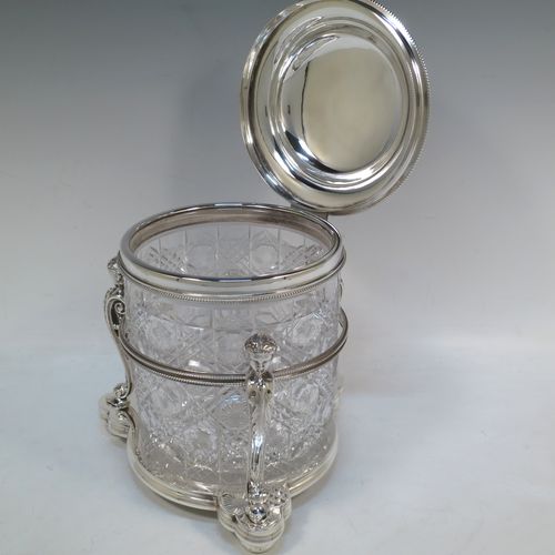 A very pretty Antique Victorian silver-plated and hand-cut crystal biscuit jar, having a hobnail and star cut body, a hinged lid with hand-engraved floral work and a cast leopards head finial, all sitting inside a galleried base with three cast caryatid figures attached to a central band and sitting on three cushion feet, all with bead-edge borders. Made by Henry Atkins of Sheffield in ca. 1880. The dimensions of this fine hand-made silver plated and crystal biscuit box are height 21.5 cms (8.5 inches), and diameter of base 15 cms (6 inches).