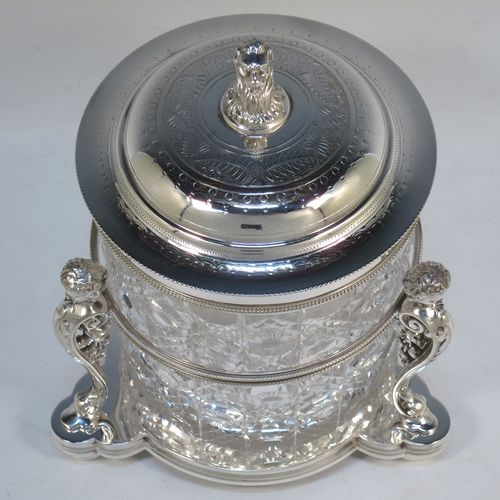 A very pretty Antique Victorian silver-plated and hand-cut crystal biscuit jar, having a hobnail and star cut body, a hinged lid with hand-engraved floral work and a cast leopards head finial, all sitting inside a galleried base with three cast caryatid figures attached to a central band and sitting on three cushion feet, all with bead-edge borders. Made by Henry Atkins of Sheffield in ca. 1880. The dimensions of this fine hand-made silver plated and crystal biscuit box are height 21.5 cms (8.5 inches), and diameter of base 15 cms (6 inches).
