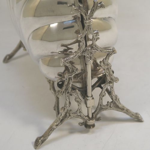 A beautiful Antique Victorian Silver Plated double folding biscuit box, having a plain shell-style body sitting in a cast tree branch designed frame, with a gold-gilt interior and original hand-pierced dividers. This very pretty antique plated biscuit box was made by James Dixon and Sons of Sheffield in ca. 1880. The dimensions of this fine hand-made antique silver-plated folding biscuit box are height 26 cms (10.25 inches), length fully opened 32 cms (12.5 inches), and width 20 cms (8 inches).