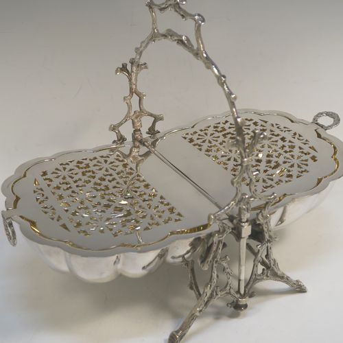 A beautiful Antique Victorian Silver Plated double folding biscuit box, having a plain shell-style body sitting in a cast tree branch designed frame, with a gold-gilt interior and original hand-pierced dividers. This very pretty antique plated biscuit box was made by James Dixon and Sons of Sheffield in ca. 1880. The dimensions of this fine hand-made antique silver-plated folding biscuit box are height 26 cms (10.25 inches), length fully opened 32 cms (12.5 inches), and width 20 cms (8 inches).