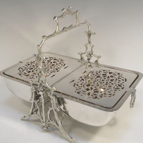 A very pretty Antique Victorian Silver Plated folding biscuit box, having an oval barrel-shaped body with beautiful hand-engraved floral decoration, sitting in a cast tree log style mechanical frame with carrying handle, and with original gold-gilt interior with hand-pierced dividers. This beautiful antique silver-plated folding biscuit box was made in ca. 1880. The dimensions of this fine hand-made silver-plated folding biscuit box are height 24 cms (9.5 inches), length fully opened 30.5 cms (12 inches), and width 20 cms (8 inches).   