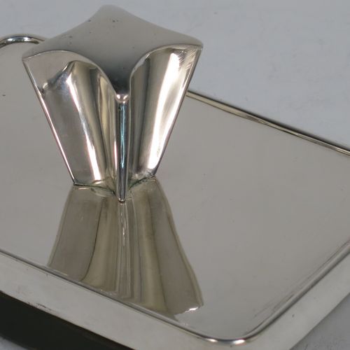 A very handsome Antique Victorian Sterling Silver Rocker Blotter, having a plain rectangular body with rounded corners, a wooden green felt covered rocker base, and an unusual scalloped handle that screws in to secure the rocker base and blotting paper to the upper body. Made by Daniel and Arter of Birmingham in 1901. The dimensions of this fine hand-made antique silver rocker blotter are length 11 cms (4.3 inches), height 6 cms (2.3 inches), and width 7.5 cms (3 inches).