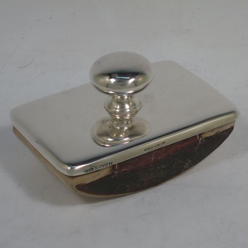 A handsome Antique Sterling Silver Rocker Blotter, having a very plain rectangular body with rounded corners, a leather covered rocker base, and a plain round handle that screws in to secure the rocker base and blotting paper to the upper body. Made by Stokes and Ireland of Chester in 1911. The dimensions of this fine hand-made antique silver rocker blotter are length 10 cms (4 inches), height 6 cms (2.3 inches), and width 6.5 cms (2.5 inches).    