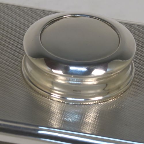 A handsome and unusual Sterling Silver Rocker Blotter, having a rectangular body with engine-turned decoration and plain chamfered borders, a plain round central handle, and a sprung steel plate held under tension that holds the blotting paper to the upper body. This beautiful silver rocker blotter was made by Turner and Simpson of Birmingham in 1956. The dimensions of this fine hand-made silver rocker blotter are length 15 cms (6 inches), height 5 cms (2 inches), width 8.5 cms (3.25 inches), and it weighs approx. 150g (4.8 ozt).