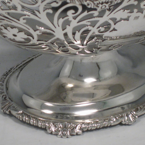 Antique Edwardian sterling silver bon-bon dish, having an oval hand-pierced body, applied shell and gadroon borders, cast shell and fluted handles, and sitting on a pedestal foot. Made by Jackson and Fullerton of London in 1904. Height 14 cms (5.5 inches), length 24 cms (9.5 inches), width 13 cms (5 inches). Weight approx. 383g (12.4 troy ounces).