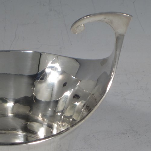 Antique Edwardian sterling silver pair of bon-bon dishes, having plain round bodies, with very unusual flying scroll handles, and each sitting on flat bases. Originally imported into, and hallmarked for, London in 1905. The dimensions of this fine pair of hand-made silver bon-bon dishes are width across handles 12 cms (4.75 inches), height 8 cms (3.25 inches), and they weigh a total of 180g (5.3 troy ounces).
