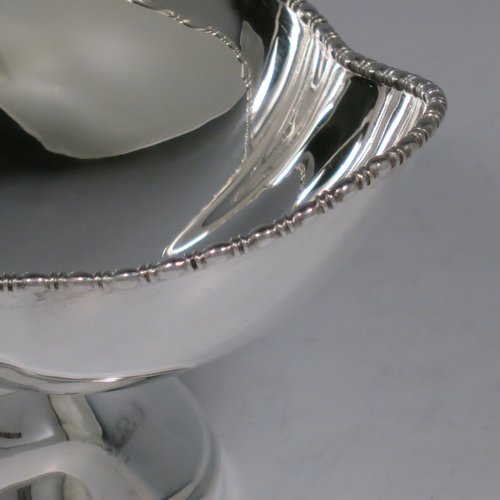 An Antique Sterling Silver pair of bon-bon dishes, having plain oval bodies, with applied and shaped egg & dart borders, and sitting on pedestal feet. Made by Henry Atkins of Sheffield in 1911. The dimensions of this fine pair of hand-made silver bon-bon dishes are length 16 cms (6.3 inches), width 11.5 cms (4.5 inches), height 8 cms (3 inches), and they weigh a total of approx. 413g (13.3 troy ounces).   