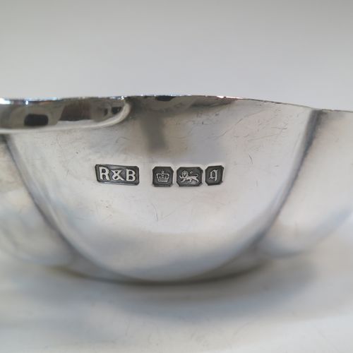 A very pretty Antique Edwardian Sterling Silver pair of bon-bon dishes, having rounded bodies with hand-chased lobed decoration, with beautiful scroll work side-handles, and all sitting on flat bases. Made by Roberts and Belk of Sheffield in 1908. The dimensions of this fine hand-made pair of antique silver bon-bon dishes are length (inc. handles) 16 cms (6.25 inches), diameter 12 cms (4.75 inches), height 3.5 cms (1.3 inches), and they weigh a total of approx. 310g (10 troy ounces).