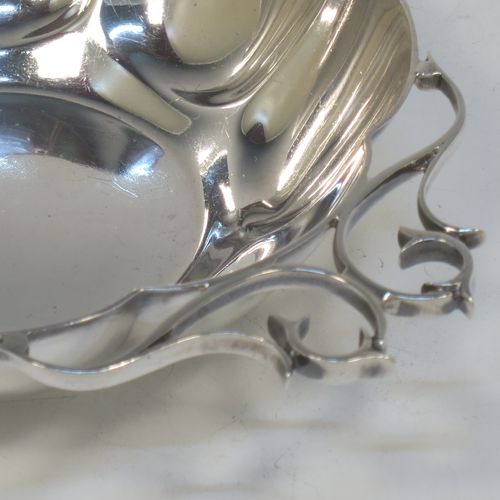 A very pretty Antique Edwardian Sterling Silver pair of bon-bon dishes, having rounded bodies with hand-chased lobed decoration, with beautiful scroll work side-handles, and all sitting on flat bases. Made by Roberts and Belk of Sheffield in 1908. The dimensions of this fine hand-made pair of antique silver bon-bon dishes are length (inc. handles) 16 cms (6.25 inches), diameter 12 cms (4.75 inches), height 3.5 cms (1.3 inches), and they weigh a total of approx. 310g (10 troy ounces).