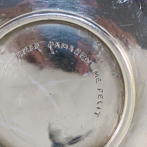 A beautiful and rare Antique Sterling Silver bon-bon dish, having a round hand-hammered body with an applied reeded border, a central applied and pierced Tudor rose with red enamelling and rope-twist border, and all sitting on a collet foot. This fantastic silver bon-bon dish was made by Omar Ramsden of London in 1924. The dimensions of this fine hand-made antique silver and enamelled dish are diameter 11 cms (4.3 inches), and it weigh approx. 87g (2.8 troy ounces). Importantly this item is engraved underneath with OMAR RAMSDEN ME FECIT.