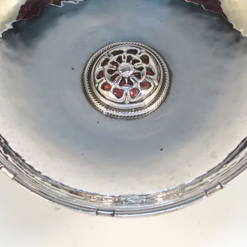 A beautiful and rare Antique Sterling Silver bon-bon dish, having a round hand-hammered body with an applied reeded border, a central applied and pierced Tudor rose with red enamelling and rope-twist border, and all sitting on a collet foot. This fantastic silver bon-bon dish was made by Omar Ramsden of London in 1924. The dimensions of this fine hand-made antique silver and enamelled dish are diameter 11 cms (4.3 inches), and it weigh approx. 87g (2.8 troy ounces). Importantly this item is engraved underneath with OMAR RAMSDEN ME FECIT.