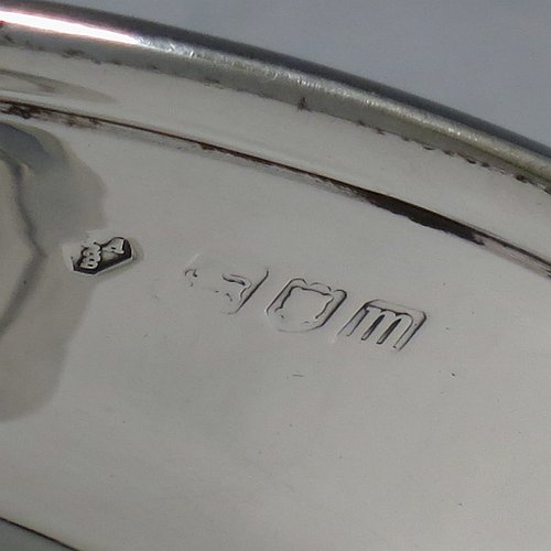 An Antique Edwardian Sterling Silver pair of bon-bon dishes, having plain round bodies, with applied reeded borders and two looped side handles, all raised above and sitting on plain round pedestal feet. Made by Holland, Aldwinkle & Slater of London in 1907. The dimensions of these fine hand-made antique silver bon-bon dishes are height 9 cms (3.5 inches), diameter 11.5 cms (4.5 inches), and they weigh a total of approx. 241g (7.8 troy ounces).