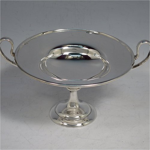 An Antique Edwardian Sterling Silver pair of bon-bon dishes, having plain round bodies, with applied reeded borders and two looped side handles, all raised above and sitting on plain round pedestal feet. Made by Holland, Aldwinkle & Slater of London in 1907. The dimensions of these fine hand-made antique silver bon-bon dishes are height 9 cms (3.5 inches), diameter 11.5 cms (4.5 inches), and they weigh a total of approx. 241g (7.8 troy ounces).