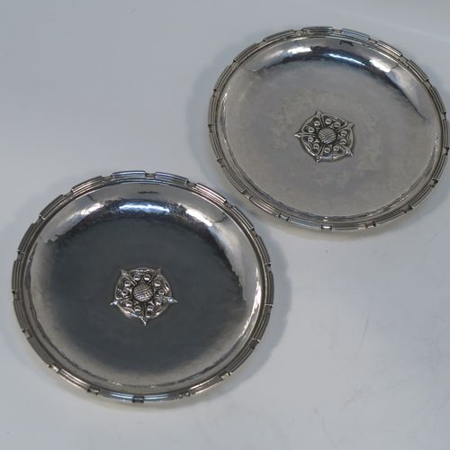 A very beautiful Sterling Silver Arts and Crafts pair of bon-bon dishes, having round hand-hammered bodies, with applied reeded cog borders, central Tudor Rose style bosses, and all sitting on round collet feet. These fantastic silver bon-bon dishes were made by Omar Ramsden of London in 1935. The dimensions of these fine hand-made Arts and Crafts silver dishes are diameter 11.5 cms (4.5 inches), and they weigh approx. 206g (6.6 troy ounces).