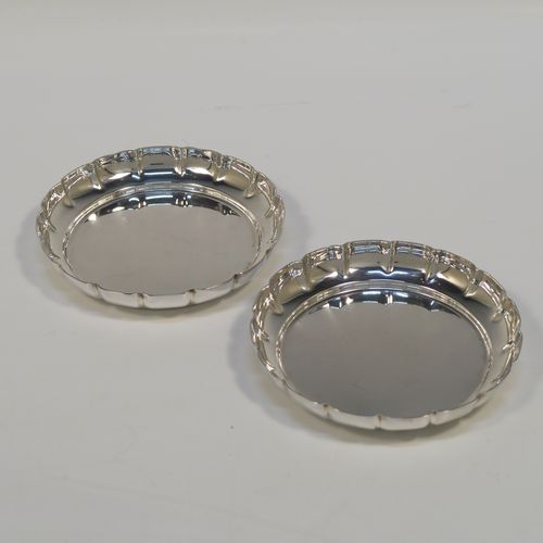 An elegant Sterling Silver pair of bon-bon dishes, having plain round bodies, with hand-chased scalloped raised borders, and sitting on flat bases. This handsome pair of silver bon-bon dishes were made by Bryan Savage of London in 1973. The dimensions of these fine hand-made silver bon-bon dishes are height 1.5 cms (0.5 inches), diameter 9 cms (3.5 inches), and they weigh a total of approx. 112g (3.6 troy ounces).   